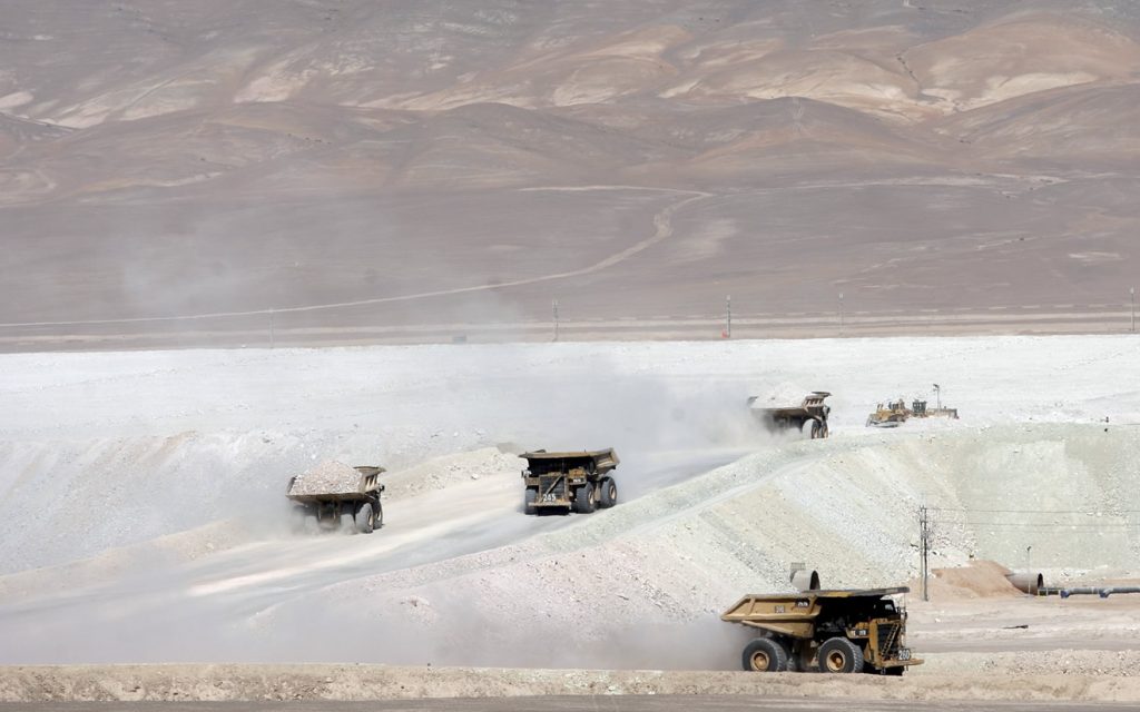 Trucks travel along road in La Escondida copper mine near Antofagasta