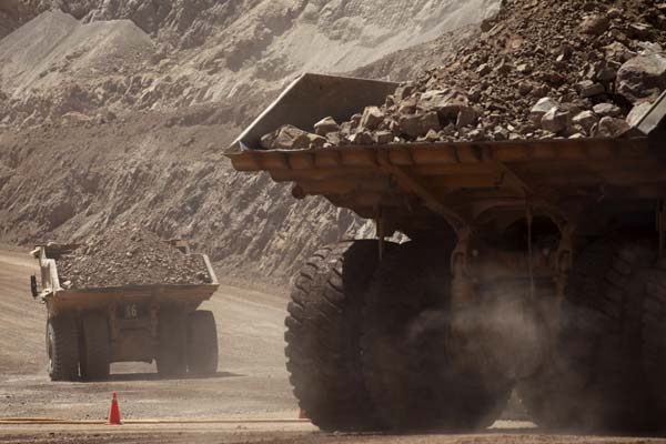 Mining trucks travel along a road at Chile's Esperanza copper mine near Calama town